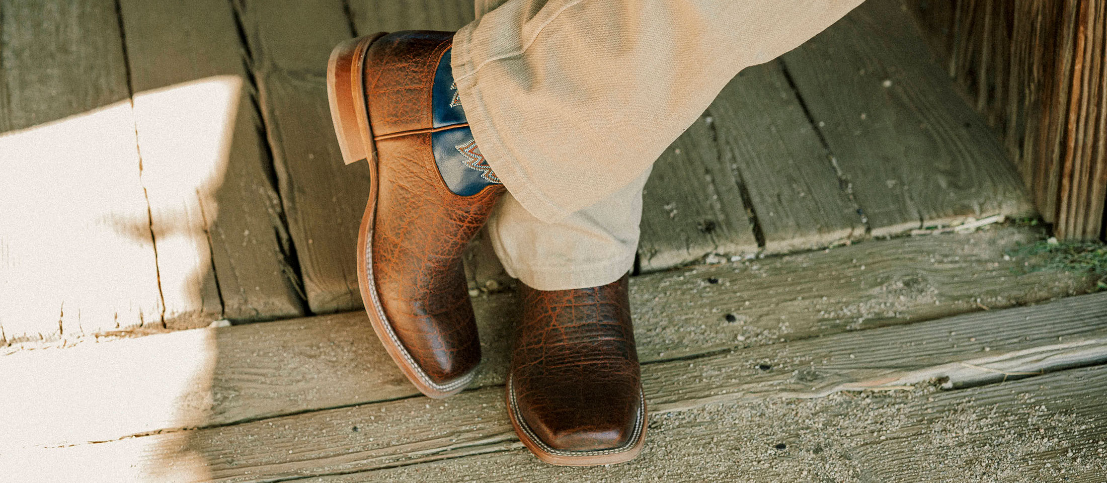 A Man Wearing the Jinglebob 11" Pull-On Western Boots in Brown